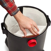 Photo of Craftsman CMXZVBE38772 vacuum bag being inserted into a black canister, top-down angle.