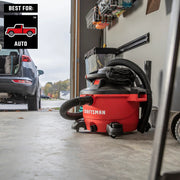 Photo of CRAFTSMAN red shop vacuum CMXZVBE38800 in a garage, hose attached, next to parked car.